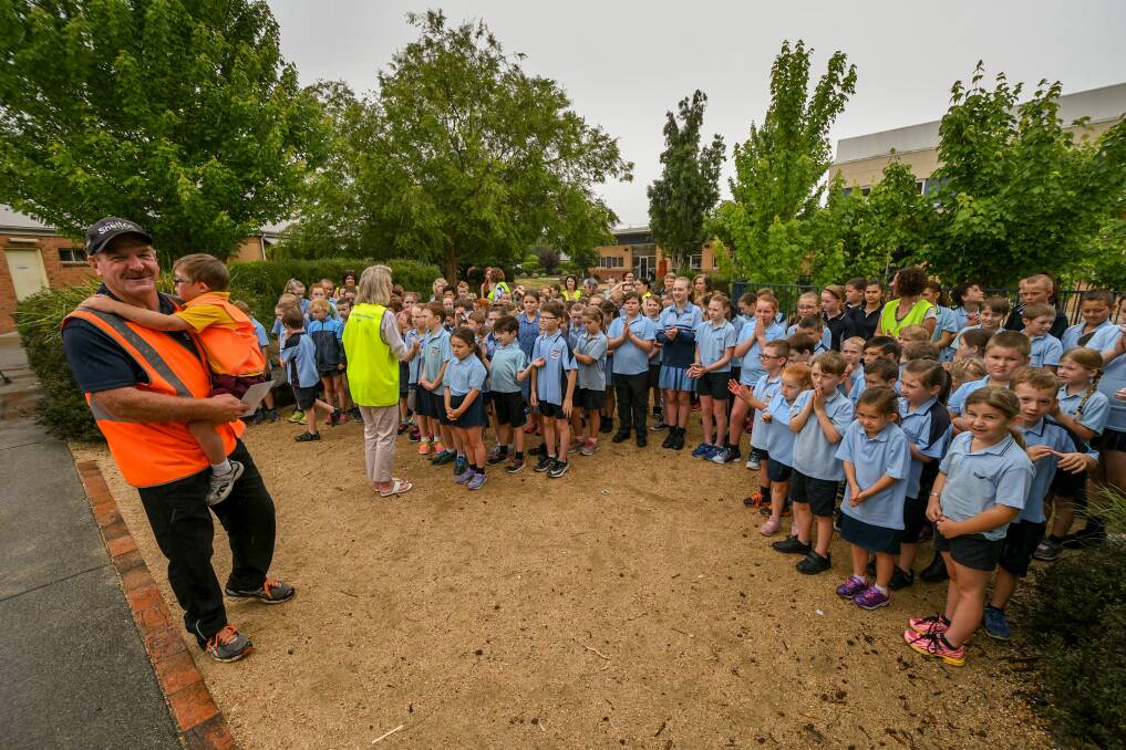 A long walk: Mark Shelton, with his grandson Evan, farewells Perth Primary School pupils, as rain begins to fall. Picture: Phillip Biggs