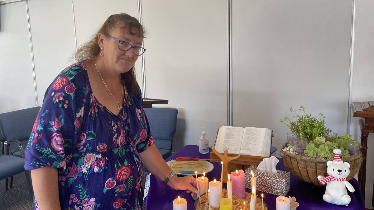 Reverend Fiona Morrison lights a candle for the five children who lost their lives during yesterday's fatal jumping castle accident. 