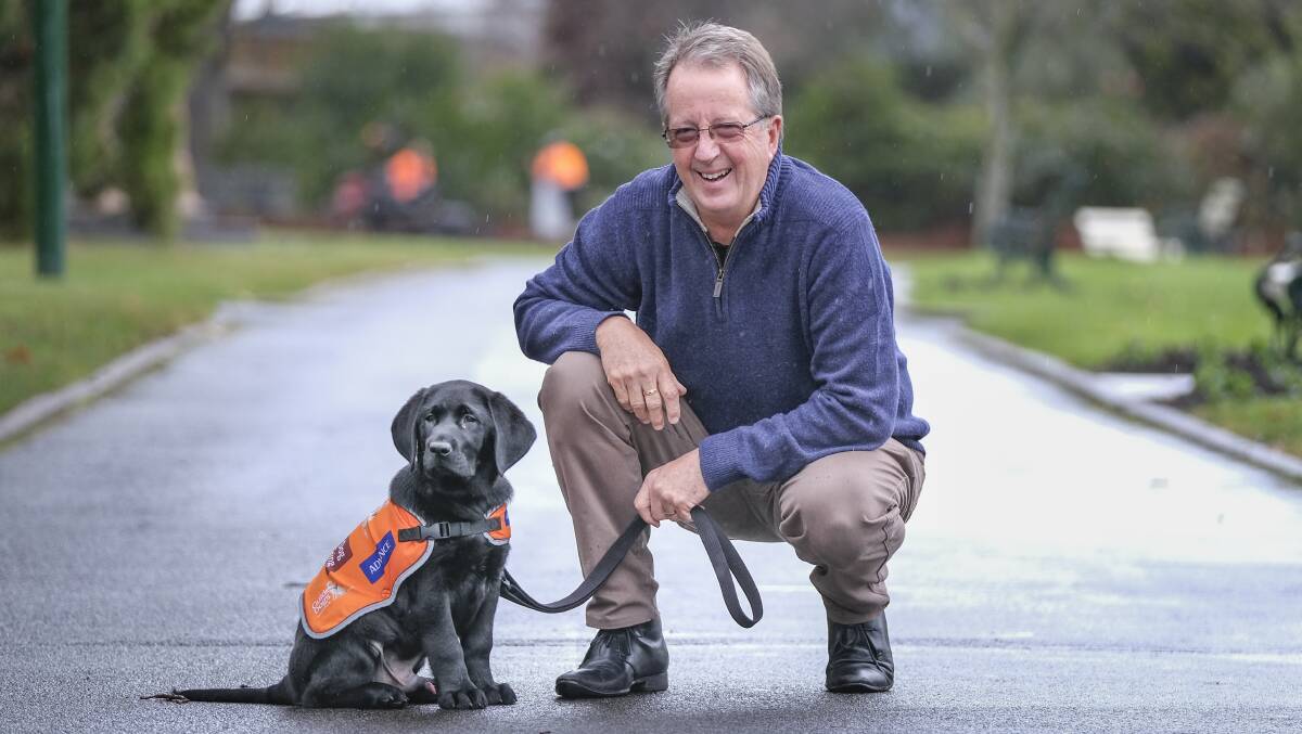 TWO GOOD BOYS: Volunteer puppy raiser Peter Cooper and training guide dog Quincy. Picture: Craig George