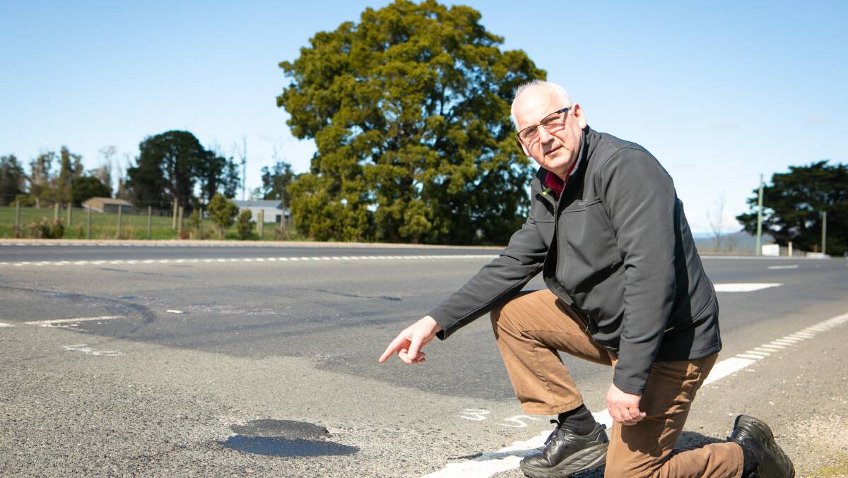 Businessman Malcolm Ryan showing the potholes in the damaged highway near Sassafras. Picture by Eve Woodhouse.