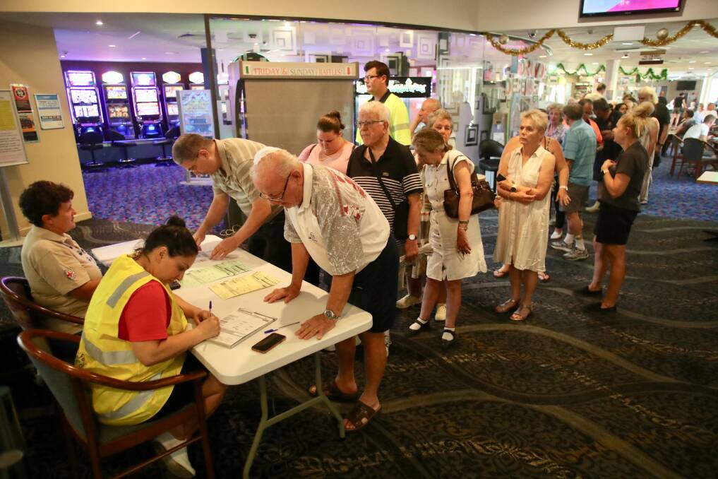 GETTING HELP: Evacuees from the Green Wattle Creek fire in New South Wales wait in line at the Picton Bowling Club to sign up for help. Charities such as the Red Cross have been widely criticised for their response to the bushfires. Picture: Adam Mclean