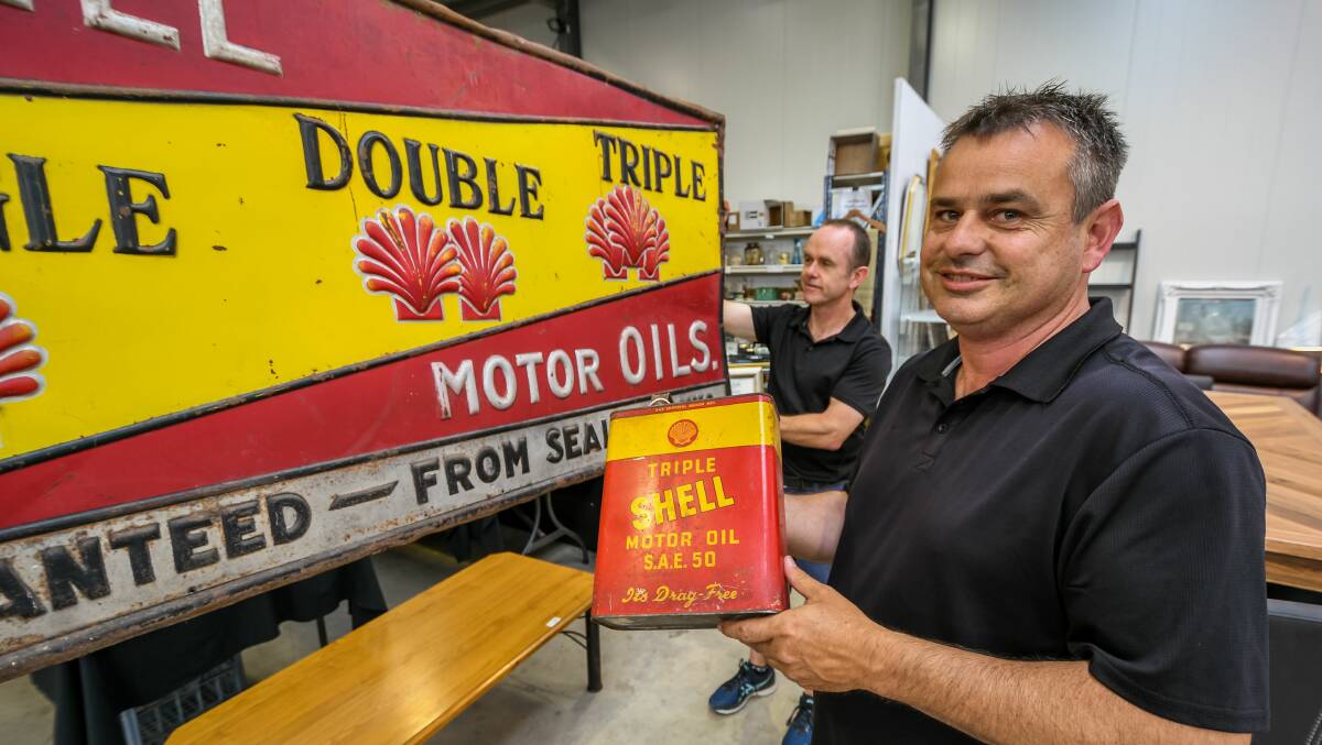 PETROL HEADS:Armitage auctioneers Neil O'Brien and Andrew Snooks wIth some of the petrol memorabilia set to go up auction. Picture: Phillip Biggs