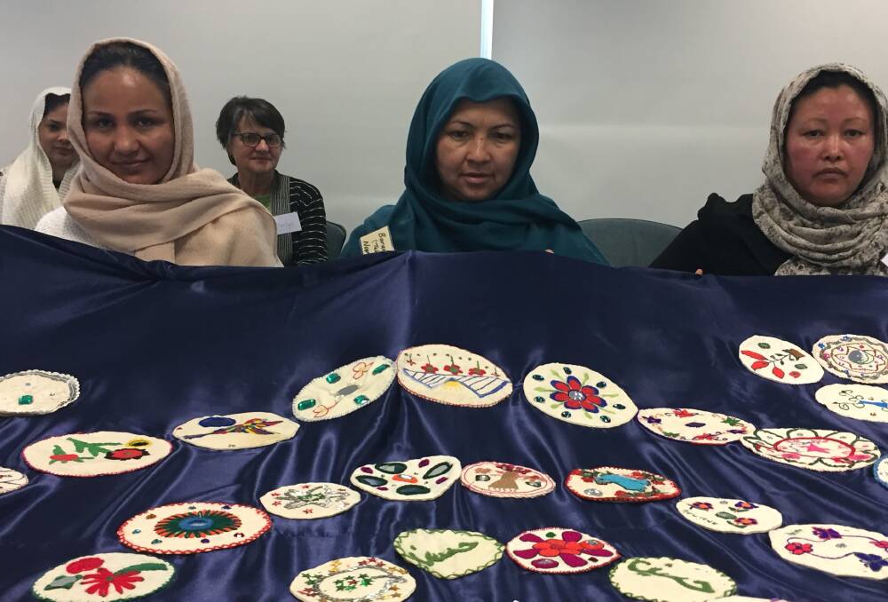 SKILL SHARING: Maryam Ahmadi, Barararbakht Norouzi and Moriya Ramezani from the Women's Friendship Group with an embroidered cloth.