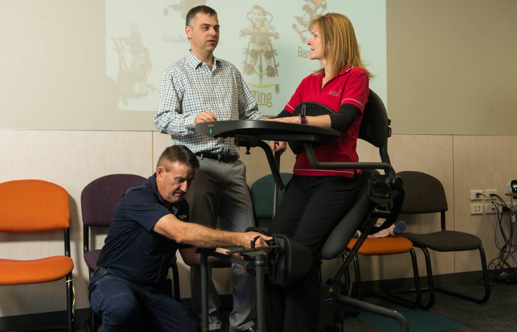 MAKING A STAND: Andrew Gardeen of Easystand demonstrates a stander with St Giles physiotherapist Tracey Redman and St Giles seating engineer David Lowe.
