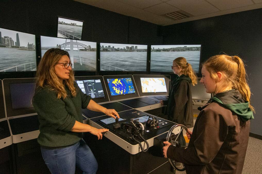 TOUR: AMC associate lecturer Helen Patronis, with Scottsdale students Zoe Clark, 14, and Caitlyn Burns, 14, in one of the simulator cubicles. Picture: Paul Scambler 