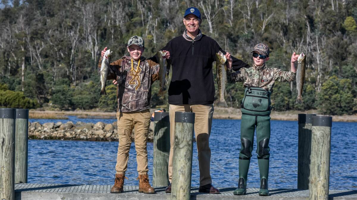 DAY OUT: Tyler Eustace, 13, and Rylan Eustace, 12, of Ulverstone, show of their trout catches with Primary Industries and Water Minister Guy Barnett. Picture: Neil Richardson 