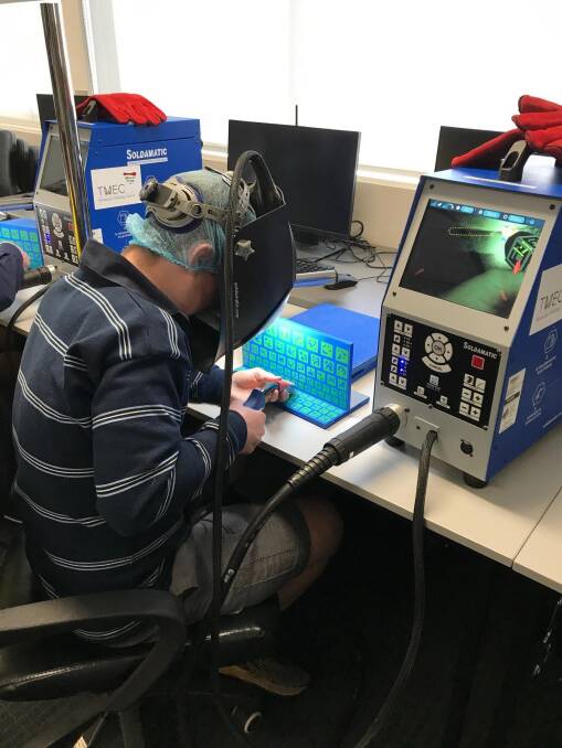 LEARNING: One of the Deloraine High School students using a virtual reality welding simulator provided by the Tasmanian Minerals Council.