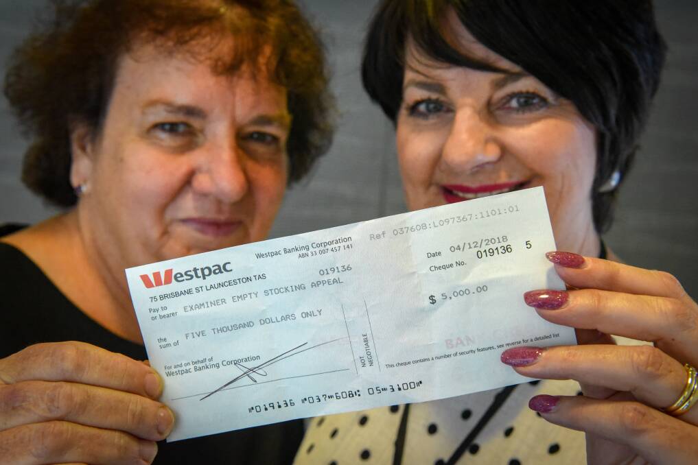 The Examiner's Kathy Nicholas and Julie Harvey with the $5000 anonymous cheque donated to the Empty Stocking Appeal. Picture: Paul Scambler
