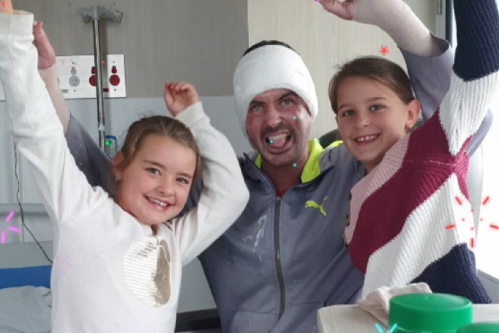 Greg Longmore, pictured with his two young daughters, is now recovering at home after receiving burns to 40 per cent of his body in a fire at Adams Distillery in February. Picture: Supplied