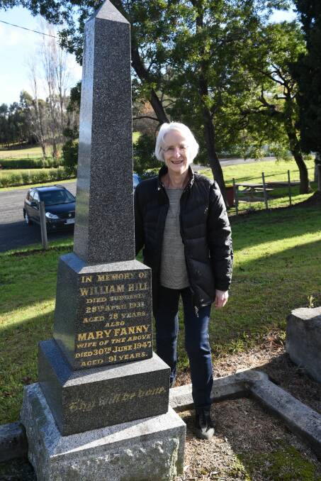 Church member Dianne Duffy stands beside a family gravestone at St Matthias' Church at Windermere. 