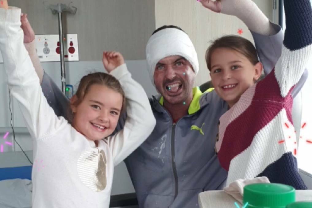 Greg Longmore, pictured with his two young daughters Indigo and Phoenix, is now recovering at home after receiving burns to 40 per cent of his body in a fire at Adams Distillery in February. Picture: Supplied