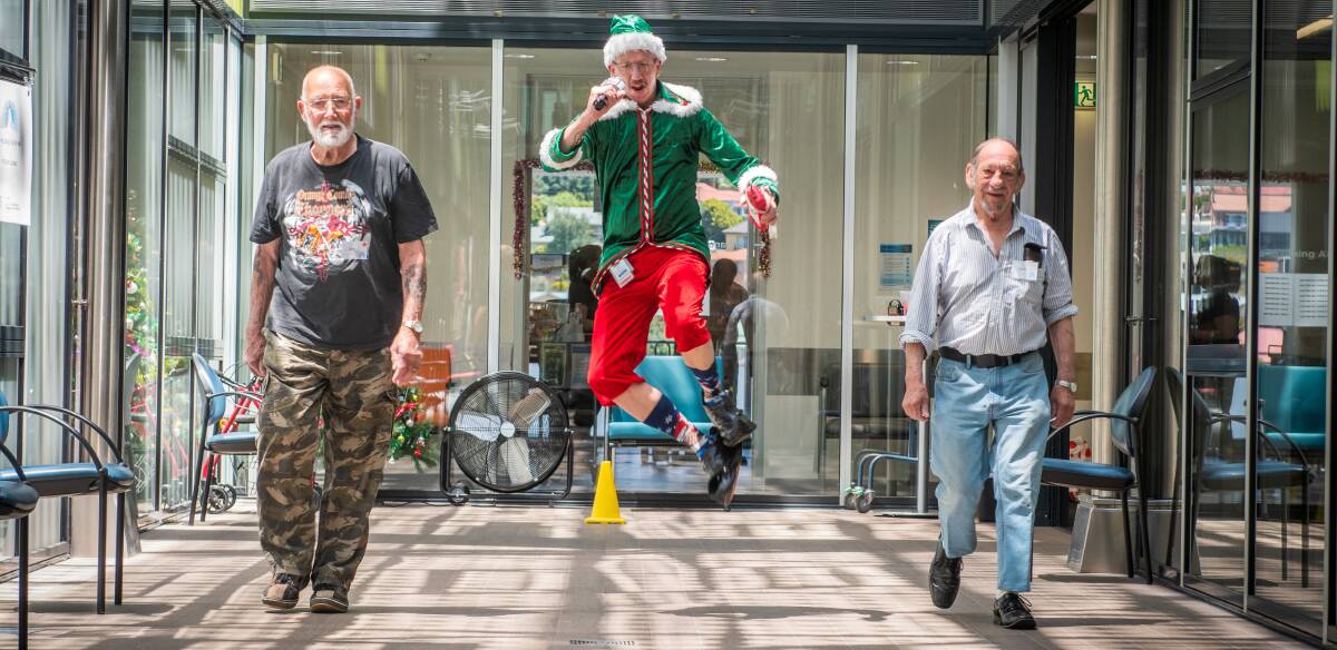 JOY: Physiotherapy assistant Mick Finney gets into the Christmas spirit while working with John Dekkers, of Longford, and Alan McCarron, of Mowbray, as part of the Lung Boosters program. Picture: Paul Scambler