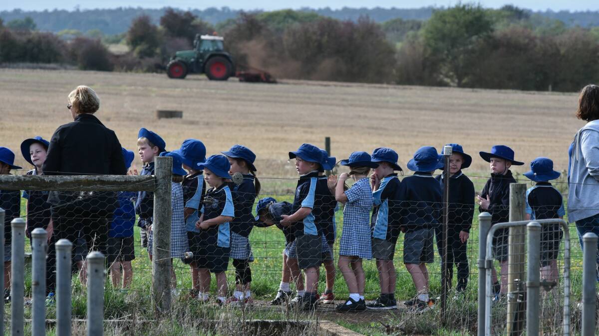 Hagley prep students on a tour of the farm, including a tractor at work. 