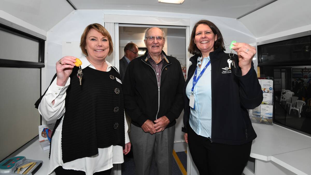 RFDS primary care workers Zoe Page and Nicole Grose with keys to the mobile health clinics, with Rotary Tasmania Community Care chairman John Dare. Pictures: Neil Richardson 