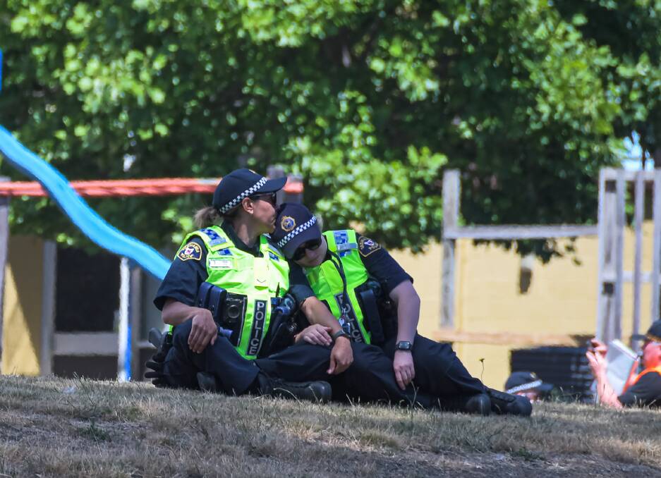 DEVASTATED: Police comfort each other at the scene, shortly after nine children fell 10 metres from the air when their jumping castle was lifted by a gust of wind. PICTURE: Simon Sturzaker