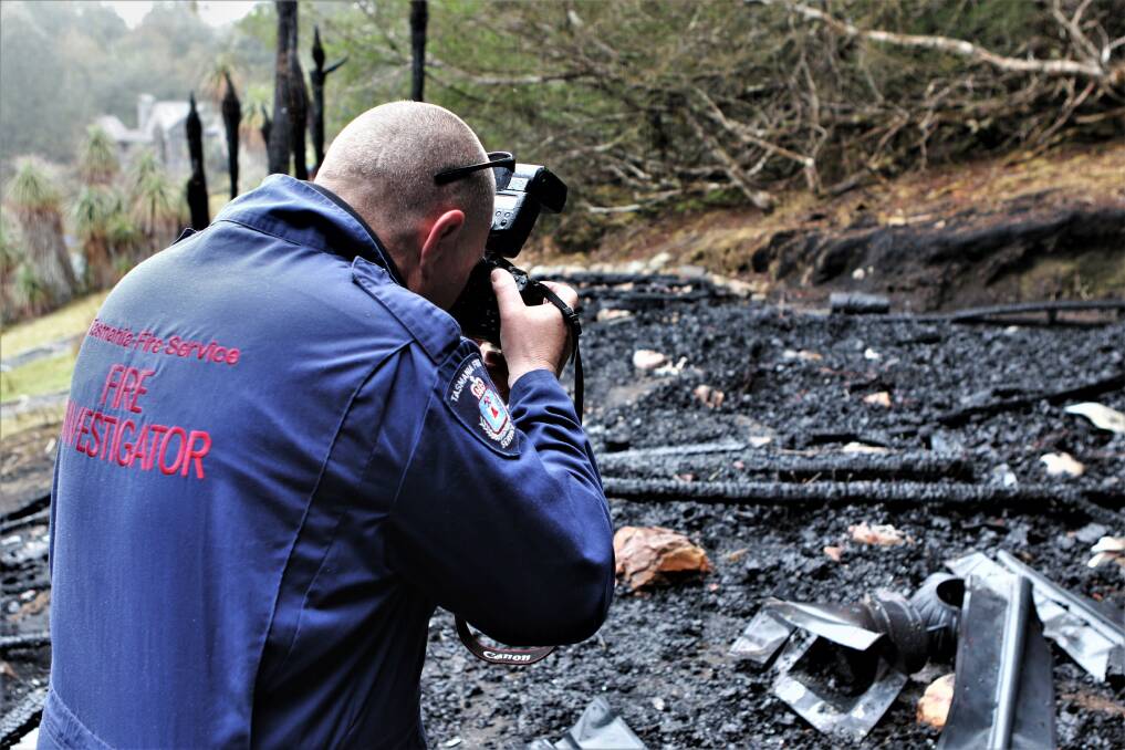 OBLITERATED: TFS fire investigator Shane Andrews carefully documents the remains after the burn. Picture: Meg Powell