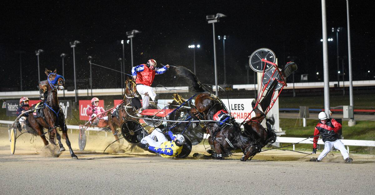 PILE-UP: Adrian Duggan (airborne), Conor Crook (on ground) and John Walters (right) crash to the track at Mowbray on Sunday night. Duggan and Crook were taken to hospital. The horses escaped serious injury. Picture: Stacey Lear