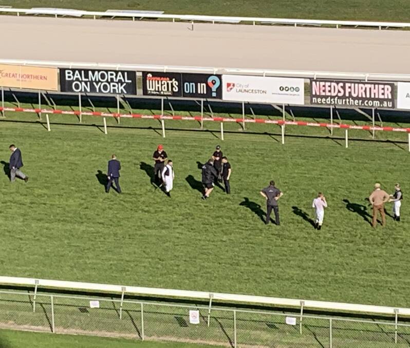 TRACK PROBLEM: Stewards, jockeys and track staff inspect holes found in the Mowbray track on Wednesday night. The meeting was later called off due to a coronavirus issue.