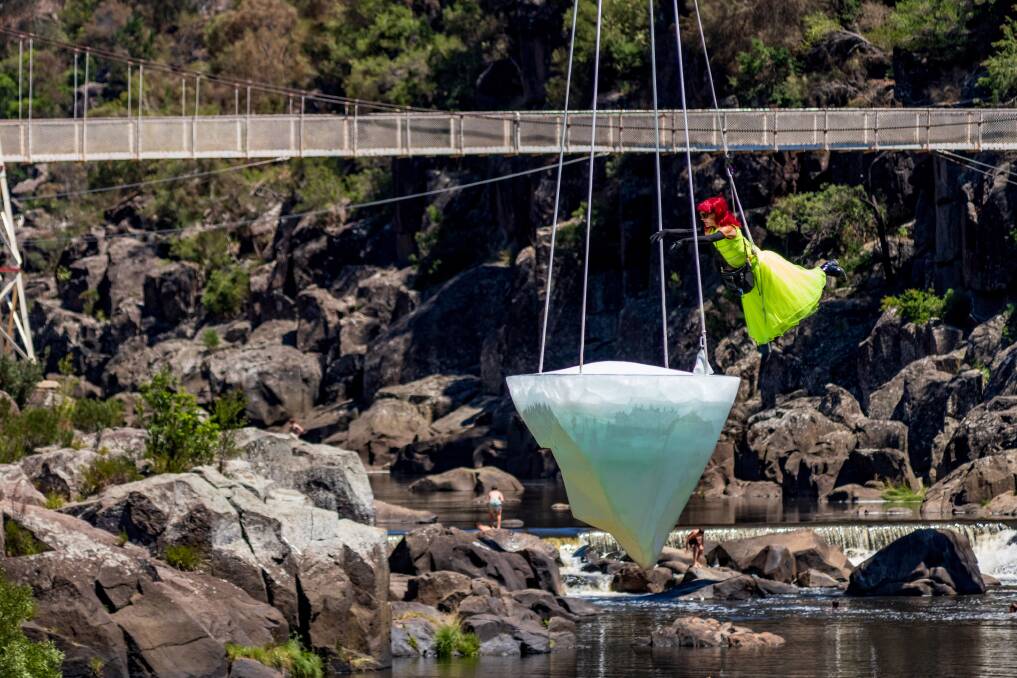 Aerialist performs on top of ice suspended over Cataract Gorge as part of Mona Foma. Picture: Phillip Biggs