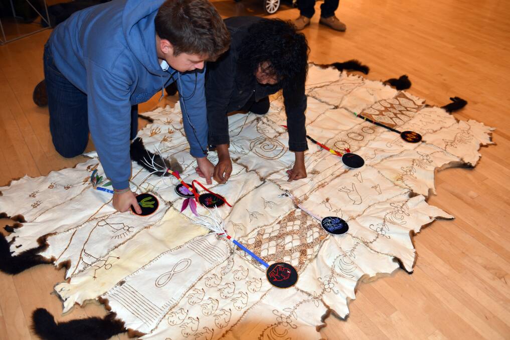 Adrian Stimson and Meryl McMaster painting possum skin cloak. Pictures: Rosalie Favell