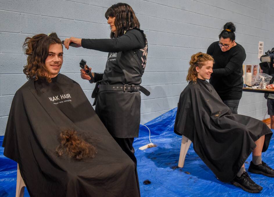 Jesse Egan Grade 10 with stylist Loretta Atkins, and Max Jordan Grade 10 with Bronwyn Atkins, get their hair cut in a mullet style for mental health fundraiser. Pictures: Paul Scambler. 