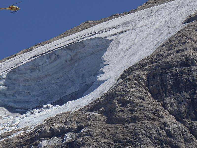 A rescue helicopter above a collapsed glacier in the Italian Alps where climbers are still missing.