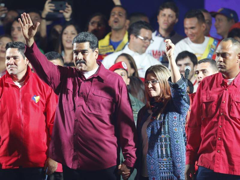 Venezuela's re-elected President Nicolas Maduro and his wife Cilia Flores wave to the crowd.
