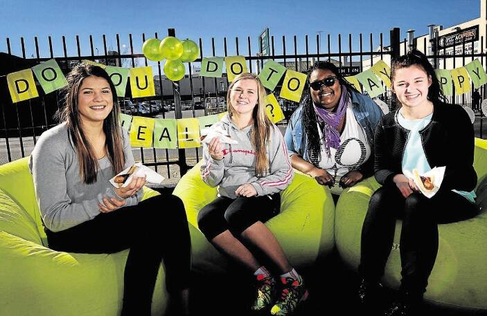 Launceston College students Alice Goss, 17, Maddy McNear, 17, and Breanna Mason, 17, make the most of a free barbecue at Headspace in Launceston yesterday with #switchitround project manager Dominique Smith. Picture: GEOFF ROBSON