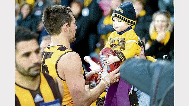 Hawthorn's Luke Hodge presents a ball to two-year-old Willow McVeigh, the son of David and Claire, of Ballarat. 
