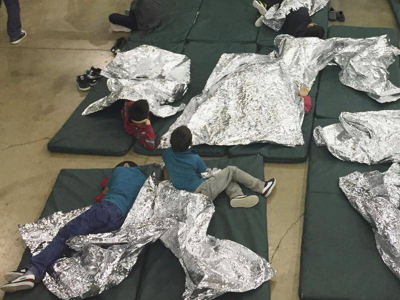 Children wait inside an old warehouse turned US immigration holding facility in South Texas.
