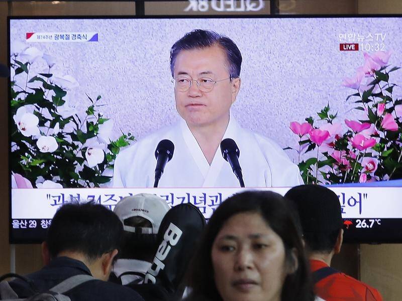 President Moon Jae-in (C) has made the offer to resolve a dispute with Japan in a televised speech.
