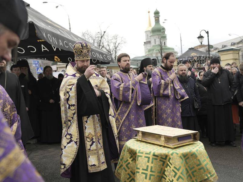 Ukrainian Orthodox Church and supporters pray after a leading priest is put under house arrest. (AP PHOTO)