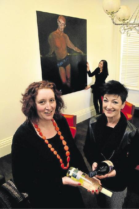 Tasdance general manager Irenee McCreevy and board member Bec Birrell in front of the Geoff Dyer portrait of Graeme Murphy to be offered at auction. Picture: PAUL SCAMBLER