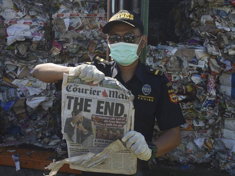 An Indonesian customs officer with an Australian newspaper found in a waste container at Surabaya.