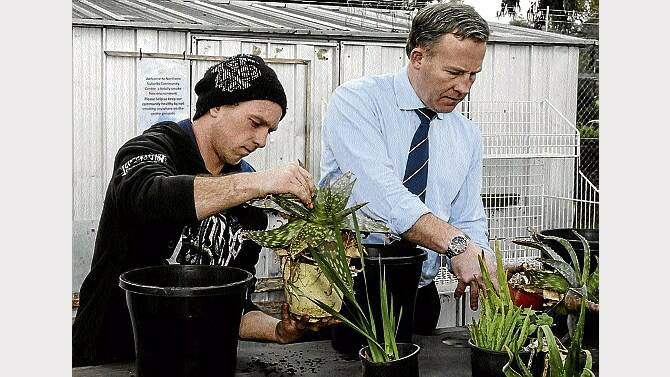Garden volunteer Yogi Glover helps Premier Will Hodgman to pot some plants. Picture: NEIL RICHARDSON