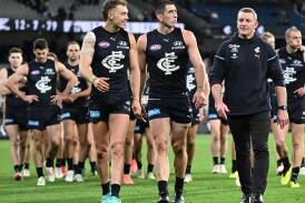 Carlton coach Michael Voss (r) is confident star Jacob Weitering (c) will remain at the Blues. (Joel Carrett/AAP PHOTOS)