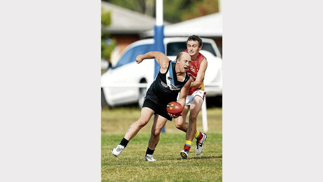 Perth's Todd Cooper tries to get a handball away under pressure from Meander Valley's Kayln Eady in last week's clash. Picture: MARK JESSER.