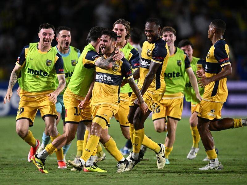 Central Coast's Mikael Doka (centre) celebrates with teammates after his stoppage-time winner. (Dan Himbrechts/AAP PHOTOS)