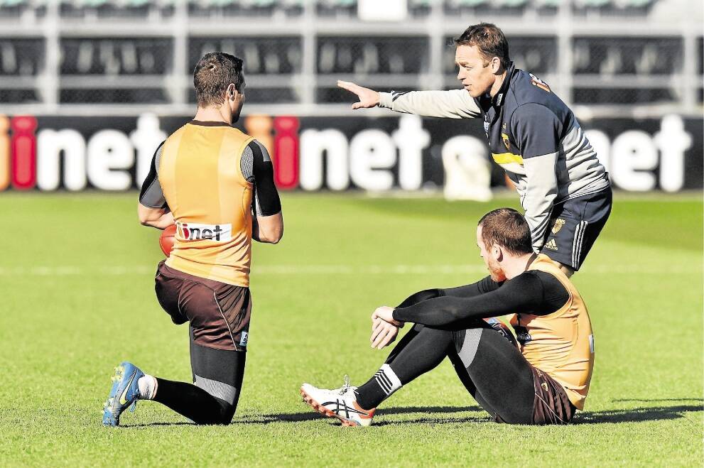 Hawthorn coach Alastair Clarkson gives direction to senior players James Frawley and Jarryd Roughead during their training session at Aurora Stadium on Friday. Picture: SCOTT GELSTON