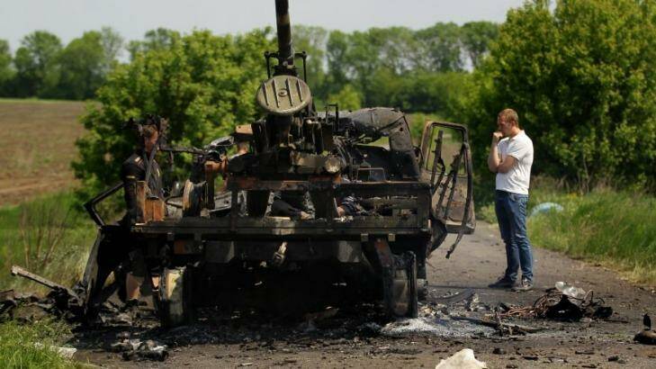 Locals stand near remains of a Ukrainian truck mounted canon, destroyed yesterday when Pro-Russian rebels attacked the Ukrainian military killing 6 soldiers and wounding 8 in Dmitrievka, East Ukraine.  Photo: Kate Geraghty