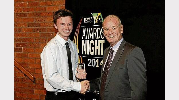 Trevallyn bowler Michael Sims receiving his national under-18 award from sponsor Ian Hopper.