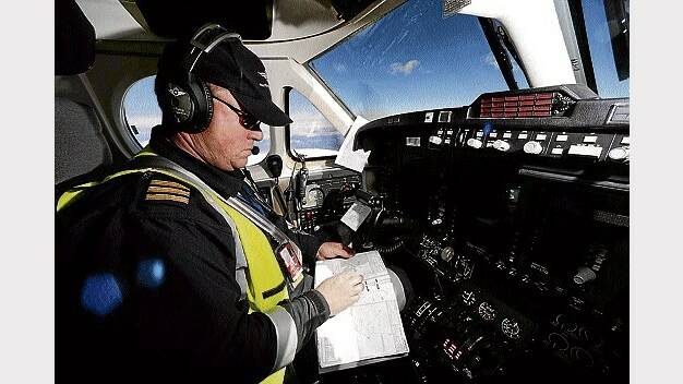 Pilot Glenn Todhunter plans his approach to the Strahan airstrip as he flies over the Great Western Tiers. 