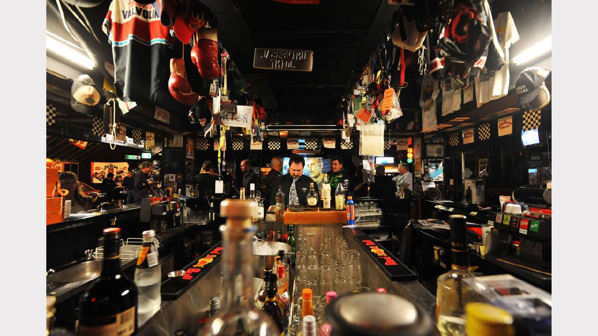 Allan Roak is surrounded by racing memorabilia as he serves customers in the Universal Joint. Picture: Scott Gelston