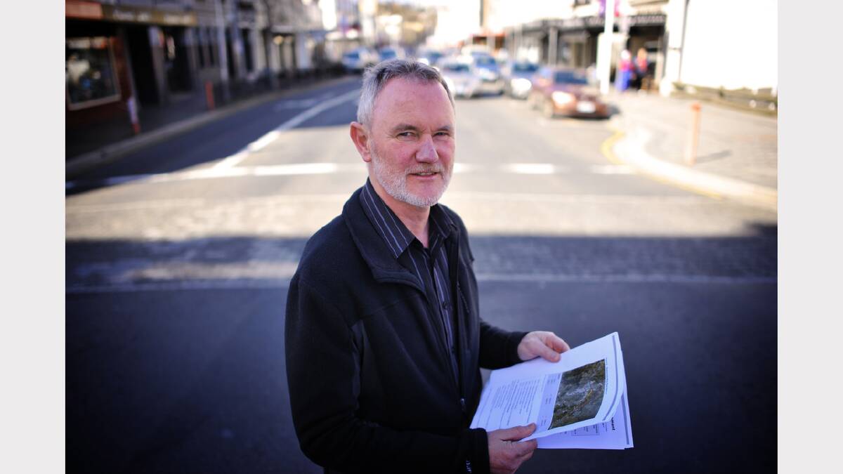 Mayor Albert van Zetten stands on Charles Street and looks over the DIER report on an Eastern Link around the city. Picture: Scott Gelston