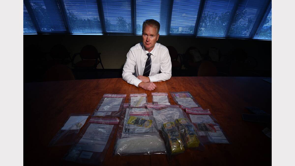 Inspector John King with cash and ice seized from a raid. Picture: SCOTT GELSTON