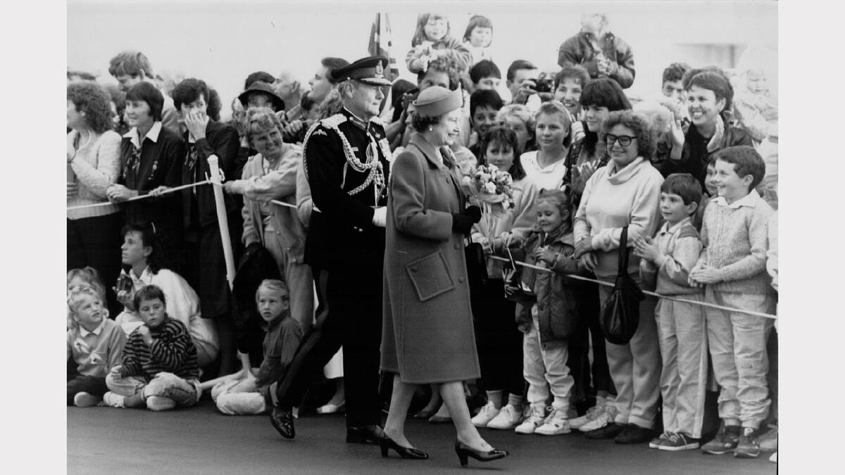 Queen Elizabeth and Prince Philip's 1988 royal visit | Governer of Tasmania Sir Phillip Bennett escorts the Queen past crowds waiting to welcome her at Hobart airport.