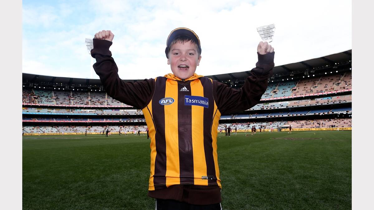 Eight-year-old Jett Hill stands triumphant on the grounds of the MCG yesterday, where he watched his mighty Hawks take down Collingwood. Picture: Pat Scala, The Age