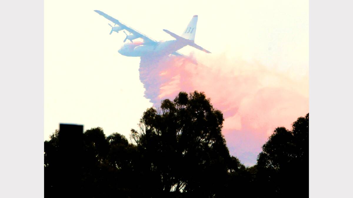 A water-bombing aircraft from Melbourne flies in to help out at the Lefroy fire on Thursday afternoon. Picture: Neil Richardson