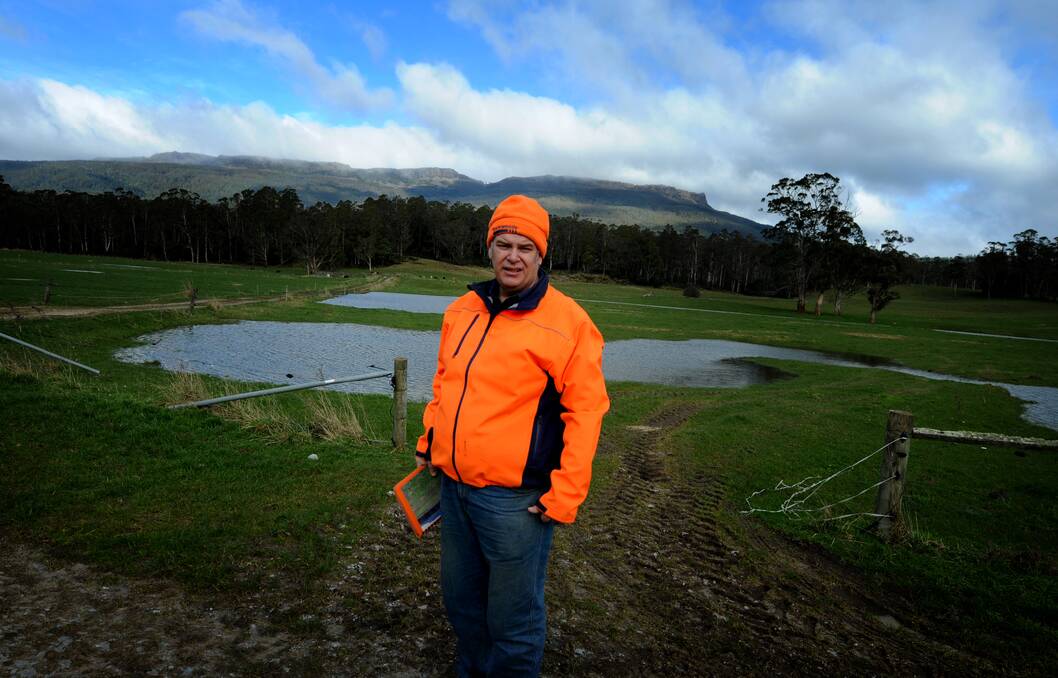 Mole Creek Farmer, Glen Anderson with water filled sink holes in the background. Picture: Geoff Robson
