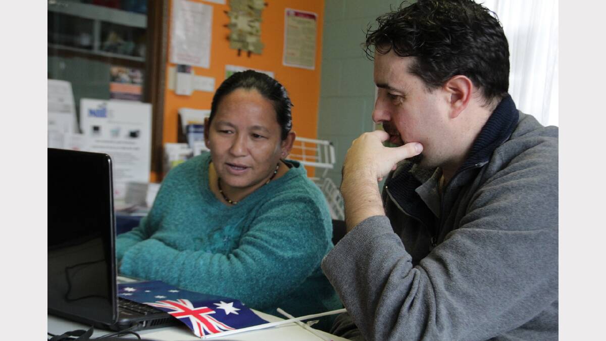 Literacy support worker Chris Howard helps Bhutanese refugee Devi Magra with a practice citizenship test.